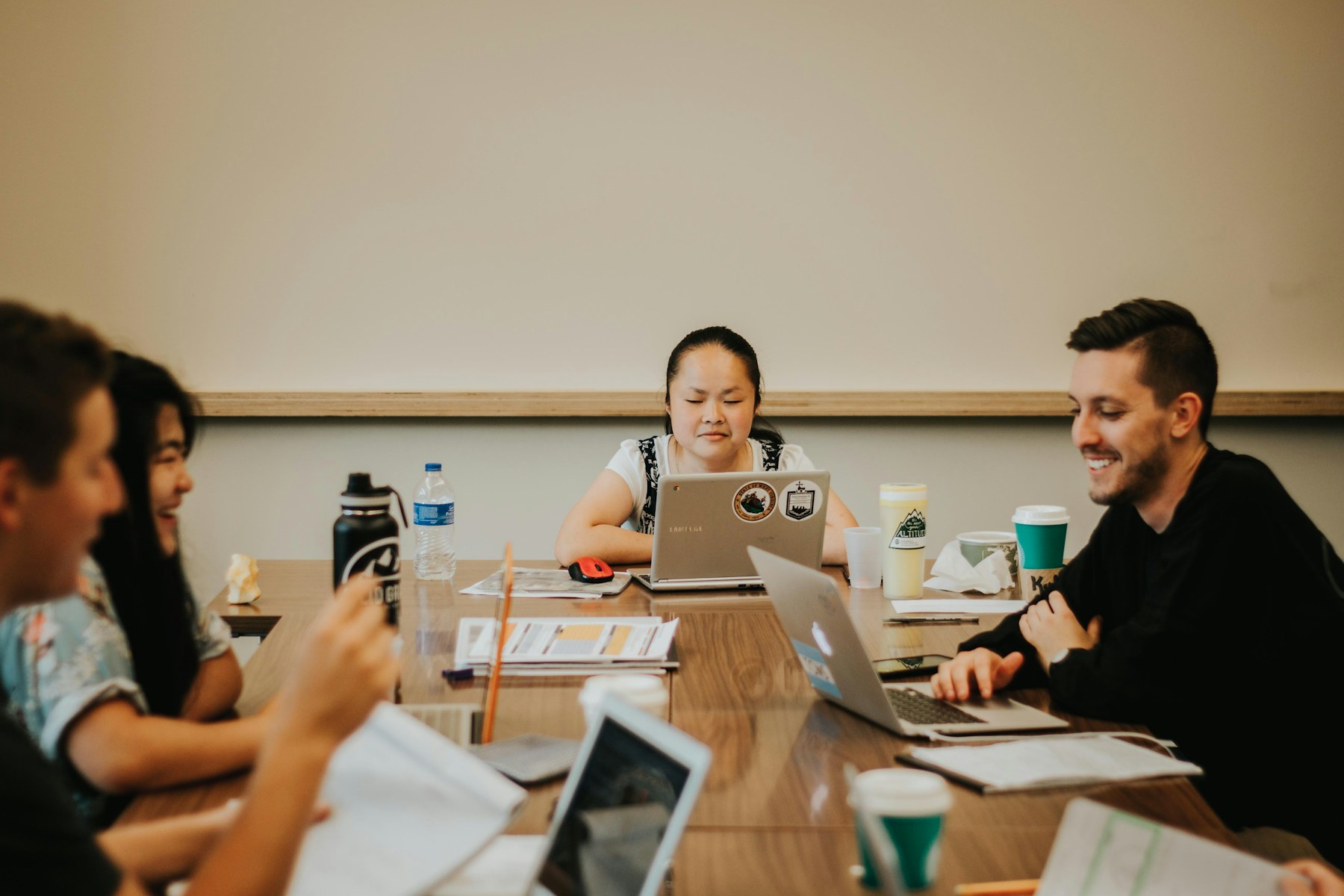 A team collaborating around laptops in a working session
